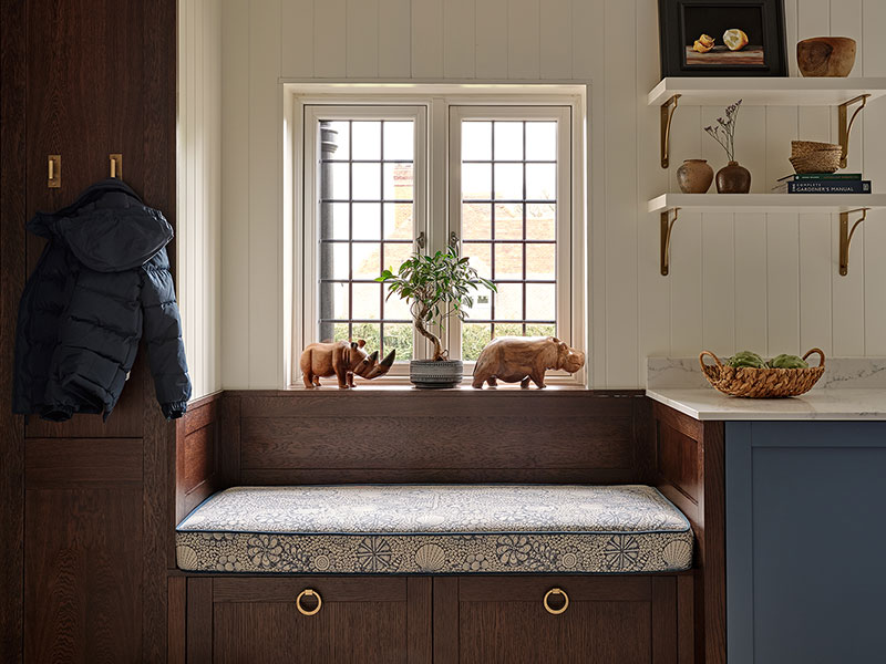 Custom oak bench seat with deep drawers for storage, seamlessly integrated into a practical and elegant utility room design