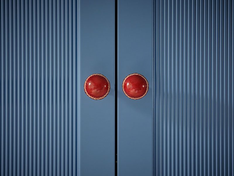 Cupboard with fluted panelling and cricket ball handles for a playful, sophisticated touch